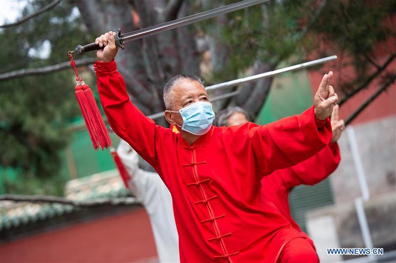 Les personnes agées pratiquent l'aérobic traditionnel au parc du Temple du Ciel à Beijing