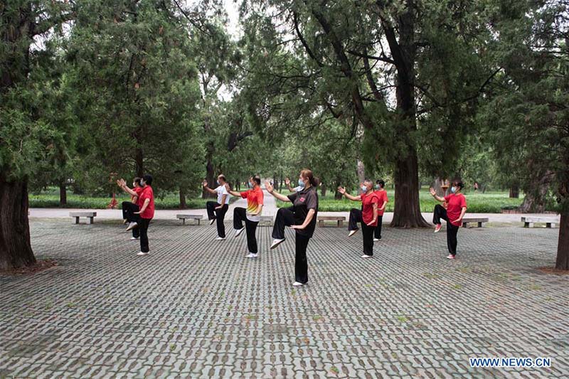 Les personnes agées pratiquent l'aérobic traditionnel au parc du Temple du Ciel à Beijing