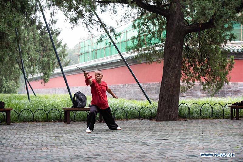 Les personnes agées pratiquent l'aérobic traditionnel au parc du Temple du Ciel à Beijing