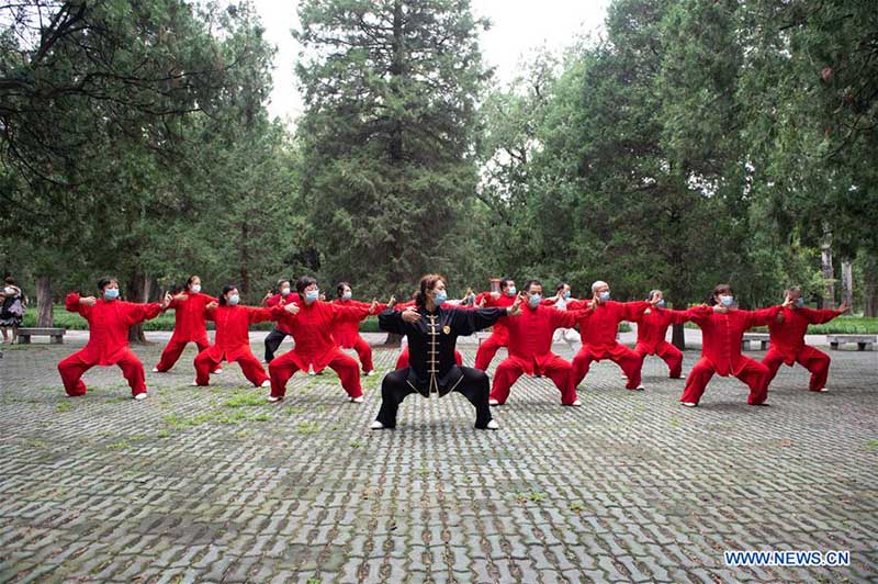 Les personnes agées pratiquent l'aérobic traditionnel au parc du Temple du Ciel à Beijing