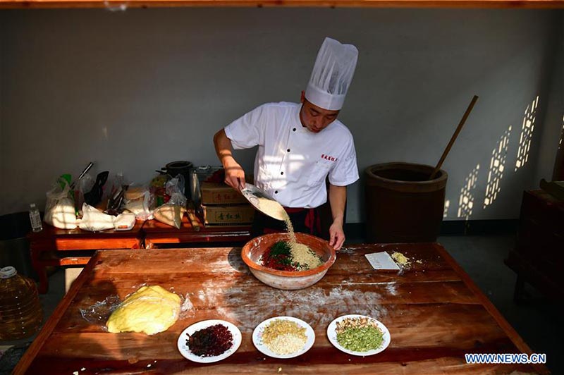 Un chef fait des gateaux de lune dans une boulangerie de gateaux de lune du Henan