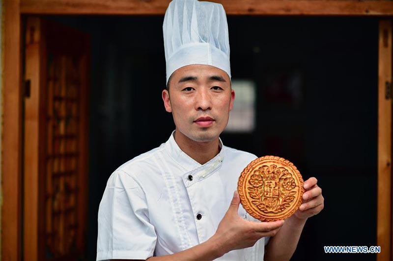 Un chef fait des gateaux de lune dans une boulangerie de gateaux de lune du Henan