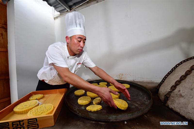 Un chef fait des gateaux de lune dans une boulangerie de gateaux de lune du Henan