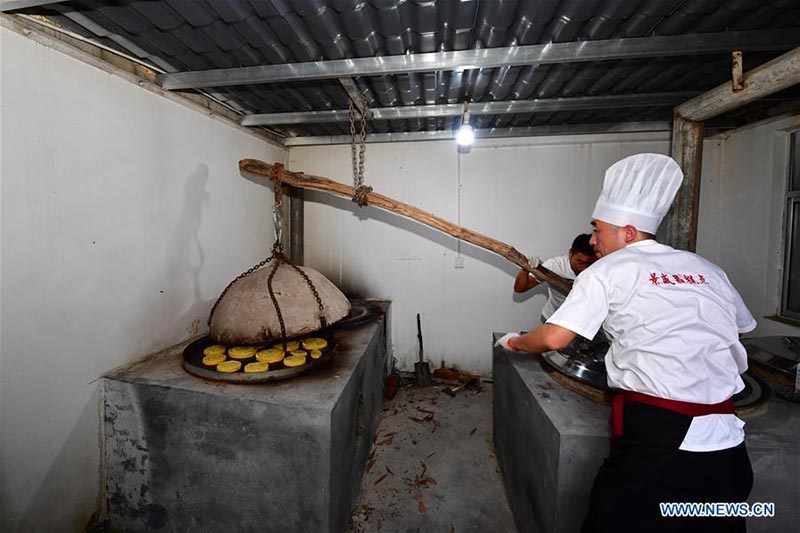 Un chef fait des gateaux de lune dans une boulangerie de gateaux de lune du Henan