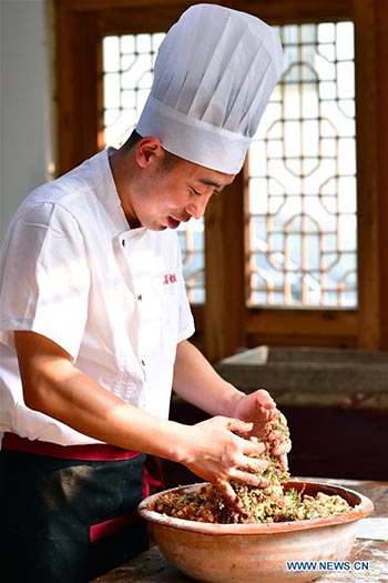 Un chef fait des gateaux de lune dans une boulangerie de gateaux de lune du Henan