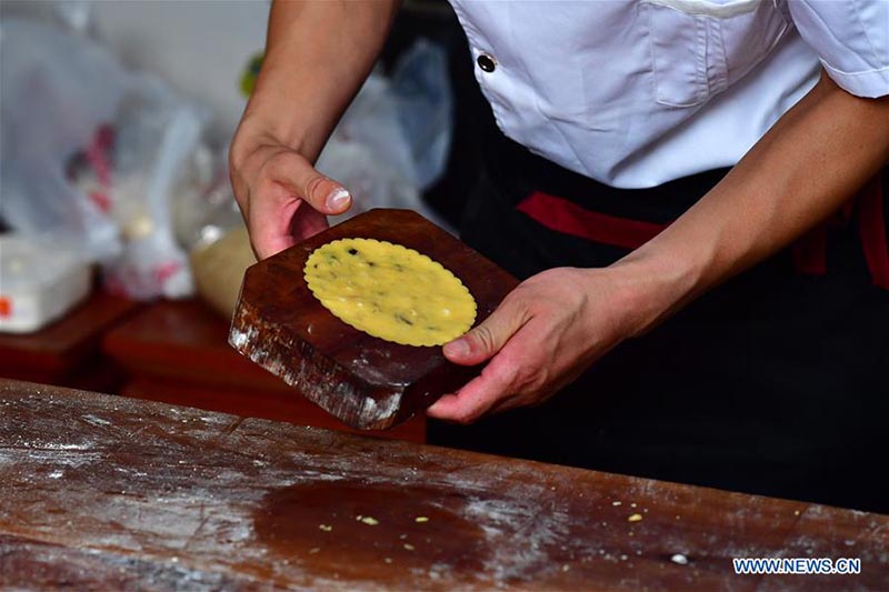 Un chef fait des gateaux de lune dans une boulangerie de gateaux de lune du Henan