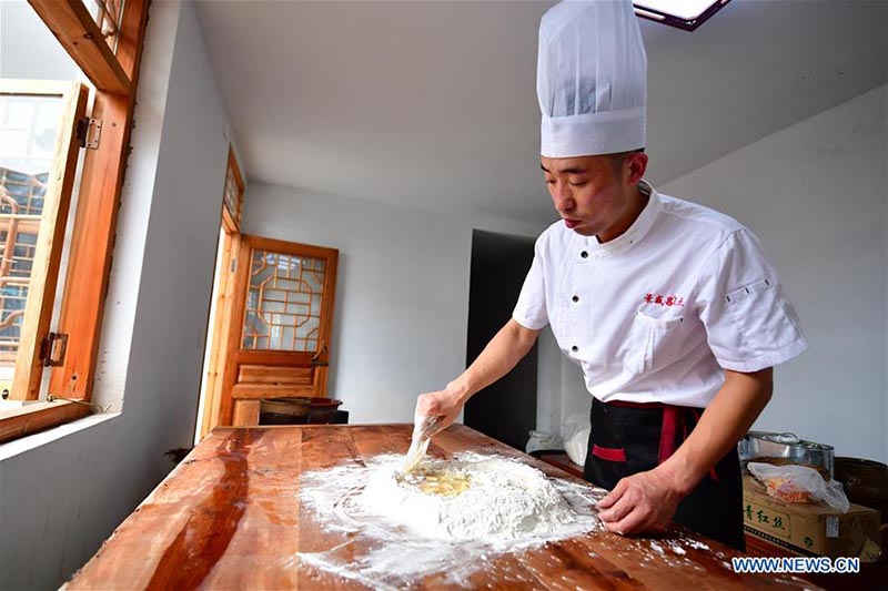 Un chef fait des gateaux de lune dans une boulangerie de gateaux de lune du Henan