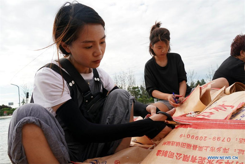 Les sauveteurs et les habitants renforcent un remblai à Xunxian, dans le Henan