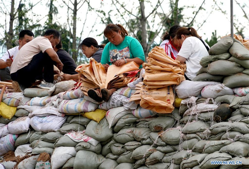 Les sauveteurs et les habitants renforcent un remblai à Xunxian, dans le Henan