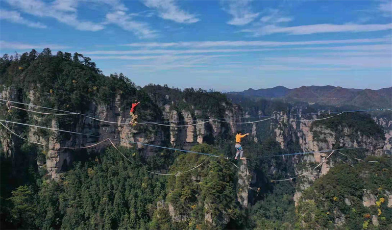 Les concurrents de slackline s'affrontent à 1 000 m d'altitude, au sommet des pics des forêts du site de Wulingyuan, dans le Hunan