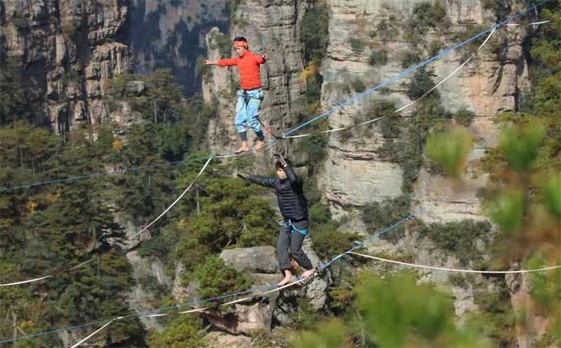 Les concurrents de slackline s'affrontent à 1 000 m d'altitude, au sommet des pics des forêts du site de Wulingyuan, dans le Hunan