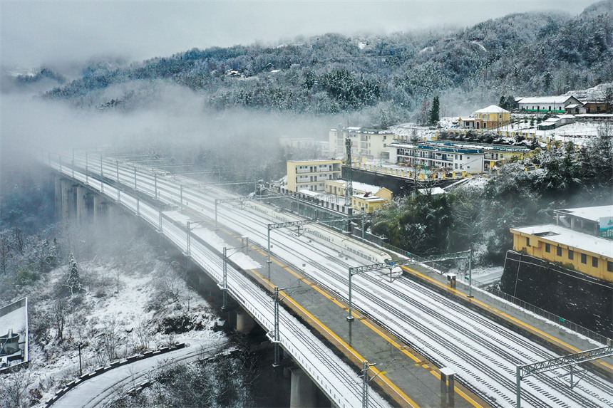 Hubei : des trains transportent des passagers le long des monts Wuling enveloppés de neige