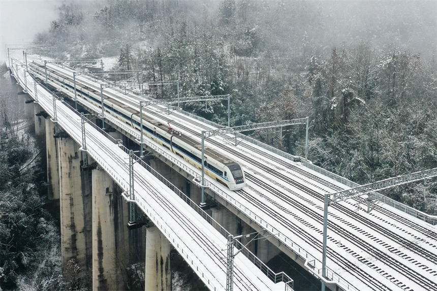 Hubei : des trains transportent des passagers le long des monts Wuling enveloppés de neige