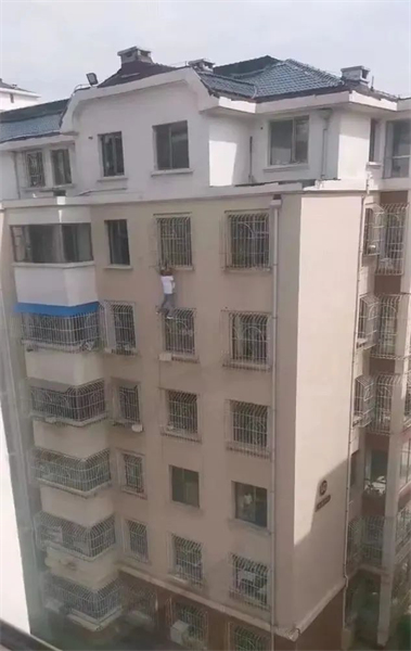 Shanxi : une petite fille coincée par le cou et suspendue dans le vide, un jeune homme grimpe à la fa?ade du batiment au cinquième étage à mains nues