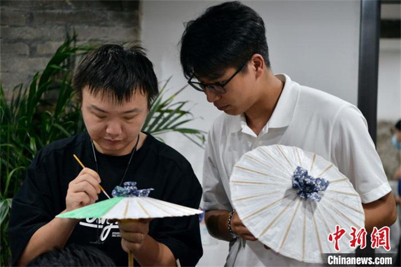 Fujian : des étudiants des deux c?tés du détroit de Taiwan apprennent à fabriquer des parapluies en papier huilé à Fuzhou