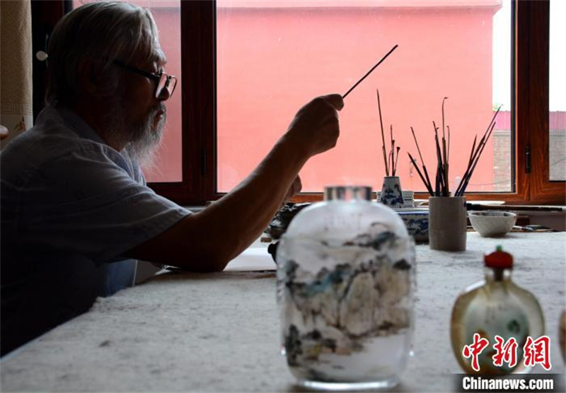 Hebei: un ma?tre de la peinture intérieure de tabatière féru d'art exerce depuis plus de 40 ans dans un village