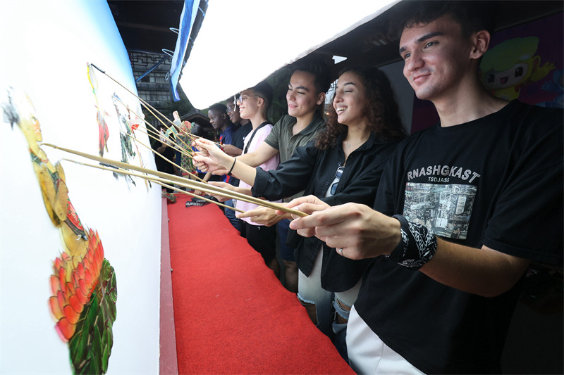 Zhejiang : des étudiants étrangers go?tent au charme du théatre d'ombres chinoises de Deqing