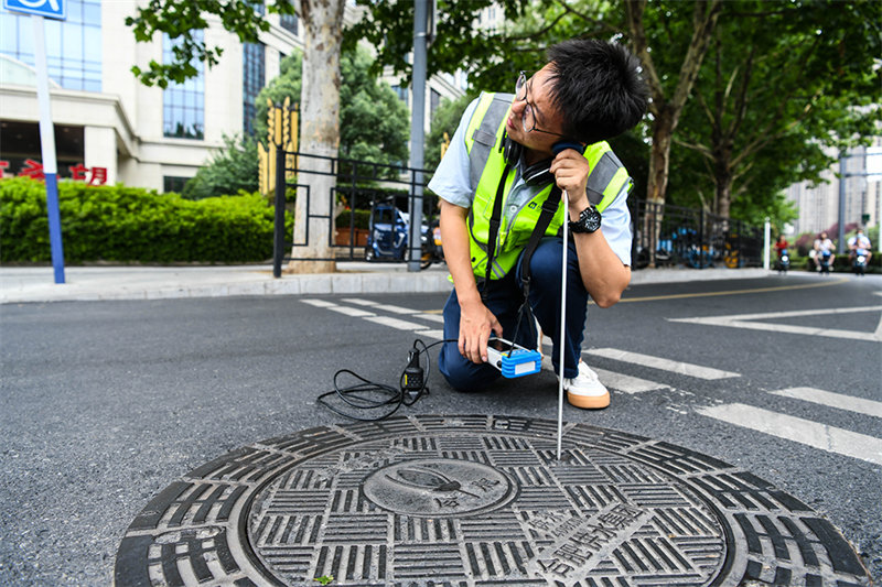 Un groupe de travailleurs Post-90 ? auscultent ? les conduites d'eau en milieu urbain