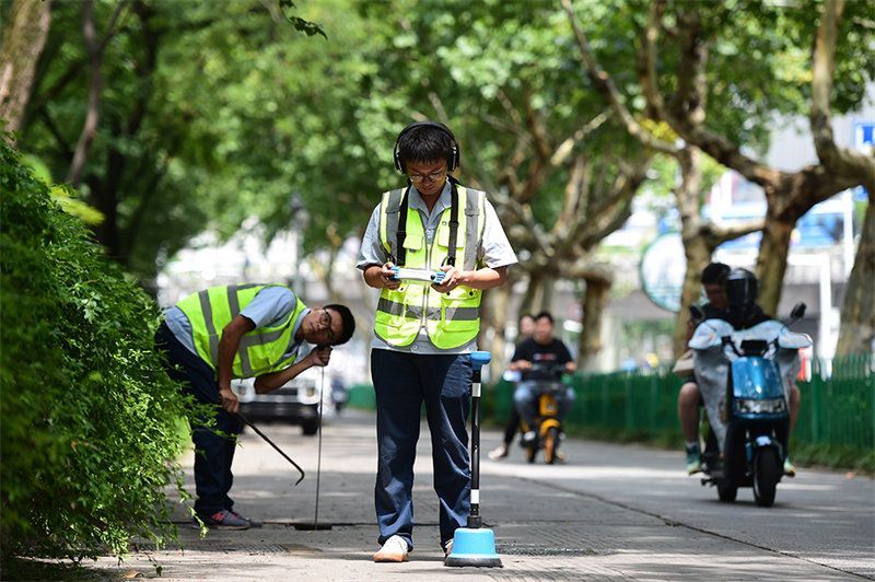 Un groupe de travailleurs Post-90 ? auscultent ? les conduites d'eau en milieu urbain