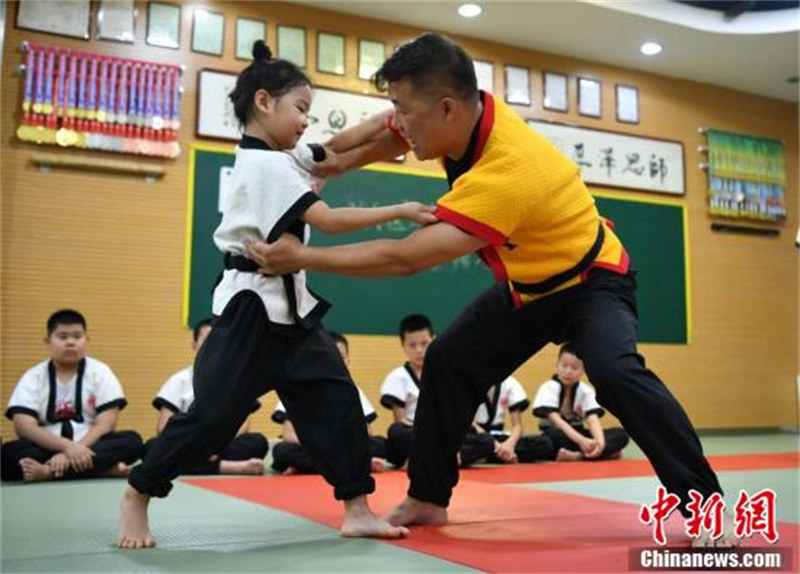 Yang Xing (à droite), héritier de la ? lutte de Kung-Fu ?, enseigne les mouvements de lutte aux étudiants dans un gymnase à Shijiazhuang, capitale de la province du Hebei (nord de la Chine), le 3 ao?t. (Zhai Siyu / China News Service)