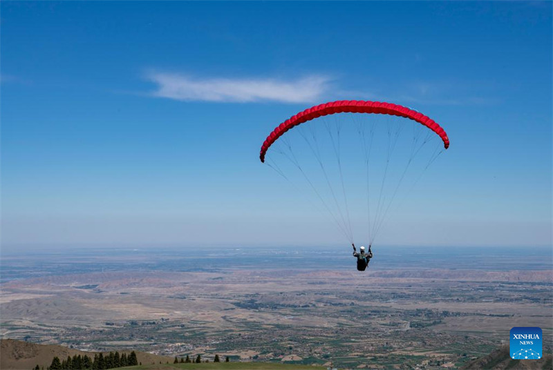 Un amateur de parapente cherche à découvrir davantage la beauté du Xinjiang depuis le ciel