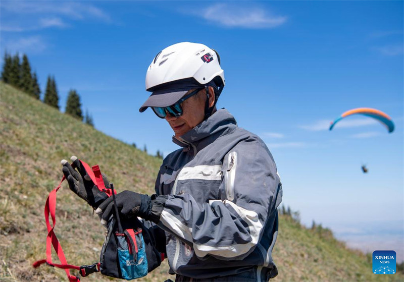 Un amateur de parapente cherche à découvrir davantage la beauté du Xinjiang depuis le ciel