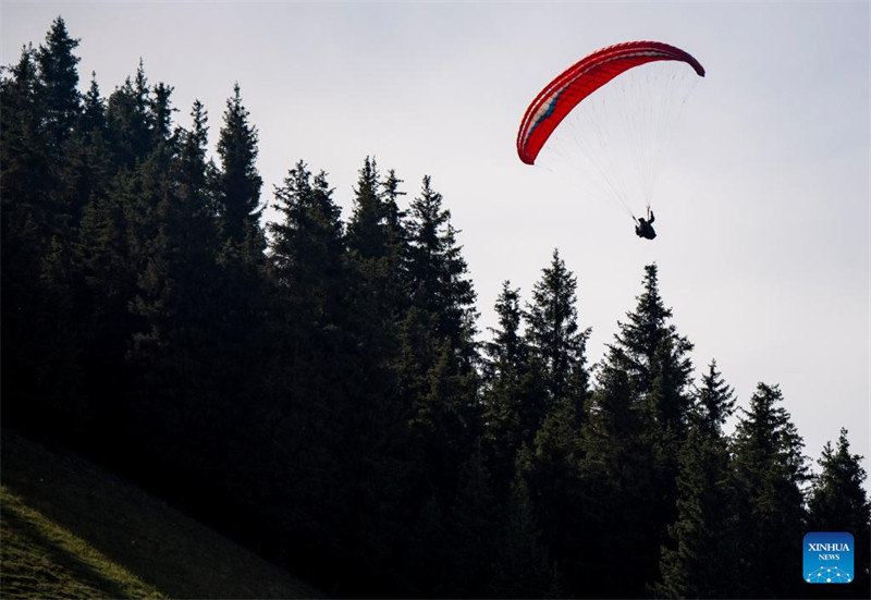 Un amateur de parapente cherche à découvrir davantage la beauté du Xinjiang depuis le ciel