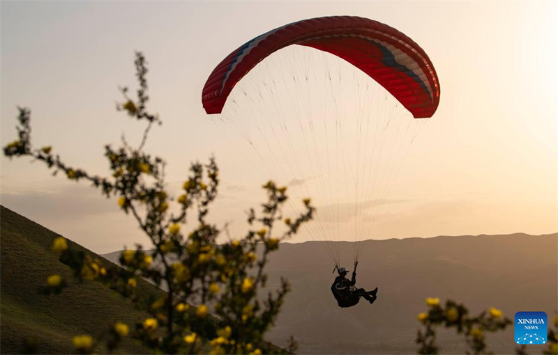 Un amateur de parapente cherche à découvrir davantage la beauté du Xinjiang depuis le ciel