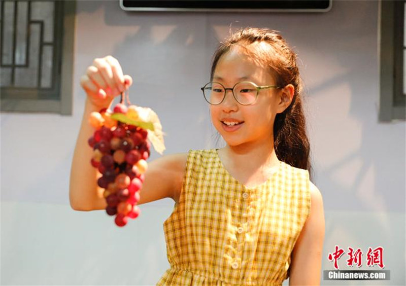 Une fillette chinoise agée de 10 ans hérite du métier traditionnel de fabrication de raisins en verre