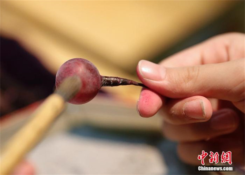 Une fillette chinoise agée de 10 ans hérite du métier traditionnel de fabrication de raisins en verre