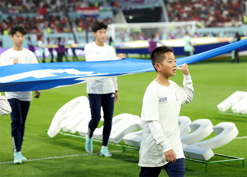 Jin Cancan (premier rang) appara?t en tant qu'un des porteurs du drapeau de la FIFA avant le match pour la troisième place entre la Croatie et le Maroc de la Coupe du Monde de la FIFA au Stade international Khalifa, à Doha, au Qatar, le 17 décembre 2022. (Photo / Xinhua)