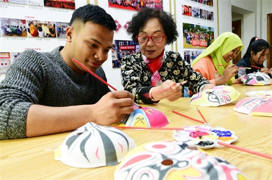 Le 24 mars 2023, des étudiants étrangers originaires du Bangladesh, du Maroc, du Pakistan, de Zambie et d'autres pays de l'Université des sciences et technologies du Jiangsu se sont rendus en visite dans la communauté de Yangjiamen de la ville de Zhenjiang, apprenant à dessiner des masques d'opéra sous la direction d'amateurs de billets d'opéra et découvrant le charme de la culture de l'opéra chinois. (Shi Yucheng / Pic.people.com.cn)