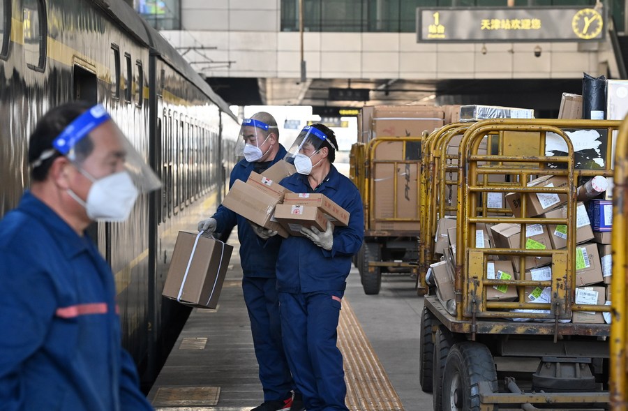  Des employés chargent des colis sur une plate-forme de la gare de Tianjin, à Tianjin, dans le nord de la Chine, le 8 février 2023. (Photo : Li Ran)