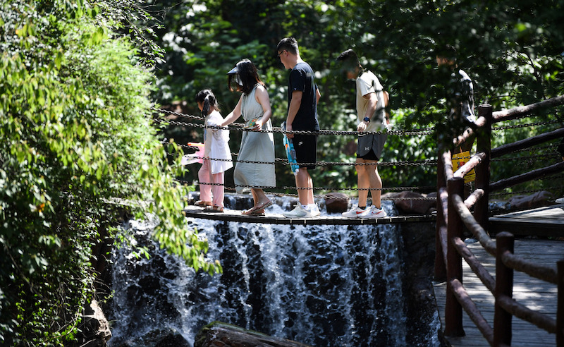 Des touristes traversent un pont sur le site touristique du mont Fuxi à Xinmi, dans la province du Henan (centre de la Chine), le 9 juillet 2023. (Photo/Xinhua)