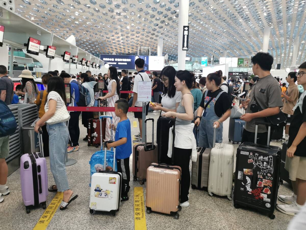 Le 9 juillet, des passagers font la queue au comptoir d