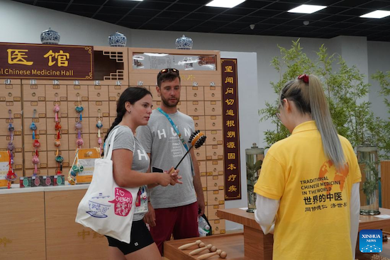 Anna Poltz, une athlète hongroise (à gauche) et sa coéquipière découvrent l'outil de soins de santé de la médecine traditionnelle chinoise (MTC) au village des Jeux de la FISU, également connus sous le nom d'Universiades, à Chengdu, capitale de la province du Sichuan (sud-ouest de la Chine), le 2 ao?t 2023. (Tang Wenhao / Xinhua)