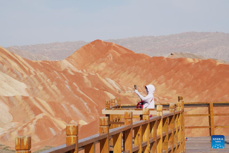 Un touriste visite le Parc géologique national de Danxia à Zhangye, dans la province du Gansu (nord-ouest de la Chine), le 7 ao?t 2023. (Ma Ning / Xinhua)