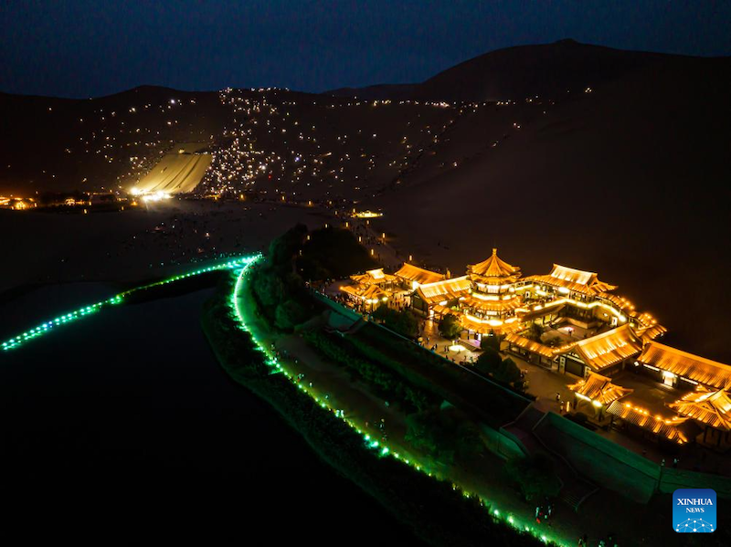 Photo aérienne montrant des touristes assistant à un concert avec les lampes de leur téléphone portable allumées sur le site touristique du mont Mingsha et de la Source du Croissant à Dunhuang, dans la province du Gansu (nord-ouest de la Chine), le 8 ao?t 2023. (Zhang Keren / Xinhua)