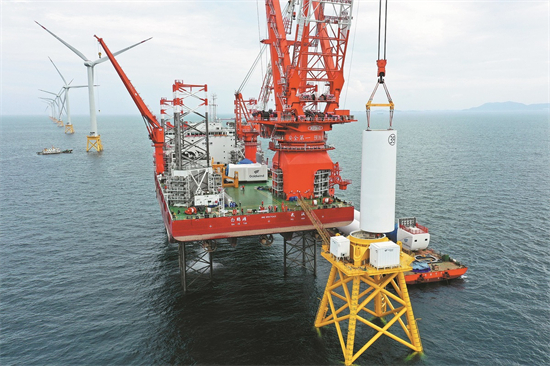 Le développement de l'énergie éolienne offshore sera bénéfique pour les zones c?tières. L'installation de la tour d'une éolienne dans le parc éolien offshore de Baihetan. (Photo/Xinhua)