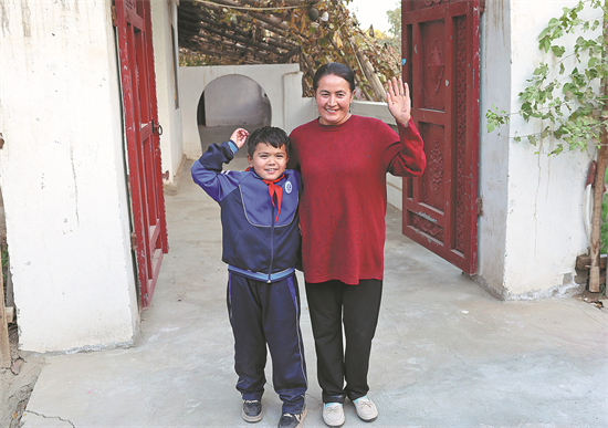 Abdulwal Abdula, 9 ans, lève le bras droit pour dire au revoir aux invités quittant sa maison dans un village du comté de Hotan, dans la région autonome ou?goure du Xinjiang (nord-ouest de la Chine), le 26 octobre. (Fong Yongbin / China Daily)