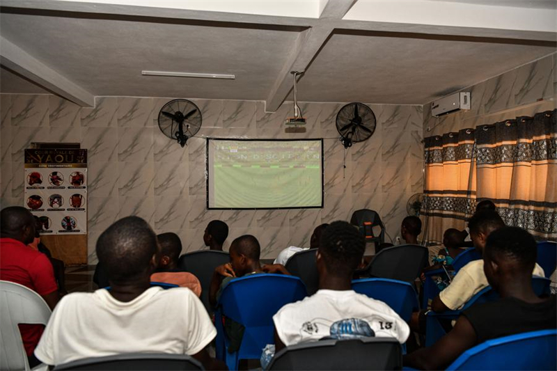 Des gens regardent les matches de la CAN 2023 grace au projet de télévision par satellite chinois dans le village de Yaou, en C?te d'Ivoire, le 14 janvier 2024. (Han Xu / Xinhua)