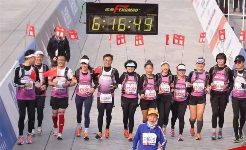 Tang Weihong (7e à partir de la droite), présidente du conseil de surveillance du Quotidien du Peuple en ligne, lors du marathon de Beijing 2022. (Photo fournie au Quotidien du Peuple en ligne)