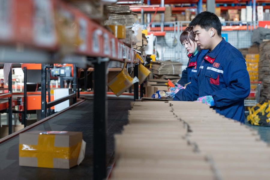 Des employés trient des colis sur un tapis roulant dans un centre logistique de la zone de Heihe de la Zone pilote de libre-échange de Chine (Heilongjiang), à Heihe, dans la province chinoise du Heilongjiang (nord-est), le 31 janvier 2024. (Photo : Xie Jianfei)