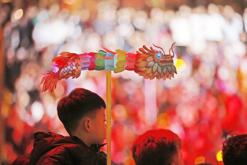 Un jeune gar?on tenant une lanterne en forme de dragon regarde un spectacle lors d'une foire du temple de la fête du Printemps dans le comté de Yancheng de la province du Shandong (est de la Chine), le 12 février 2024. (Photo / Xinhua)