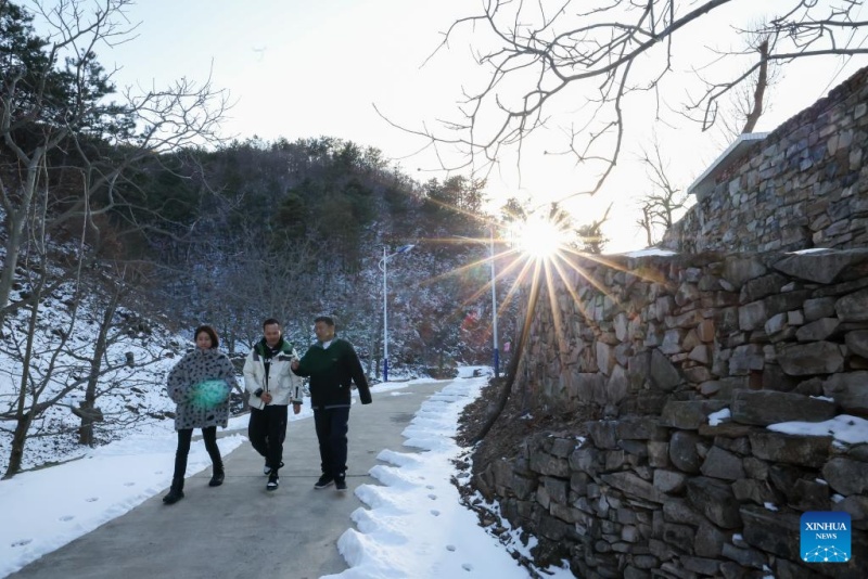 Liu Zhijun (à droite), secrétaire du Parti du village de Qian'ganjian (Tianjin), guide des investisseurs de Beijing autour du village pour vérifier les potentiels sites d'hébergement. (Sun Fanyue / Xinhua)