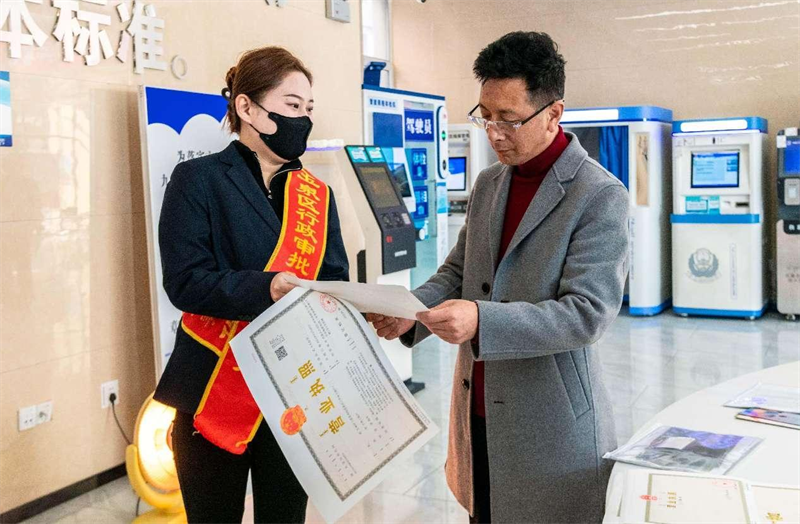 Un travailleur indépendant re?oit une licence commerciale dans un centre de services gouvernemental du district de Yuquan, à Hohhot, capitale de la région autonome de Mongolie intérieure (nord de la Chine), le 7 mars 2024. (Ding Genhou / Pic.people.com.cn)