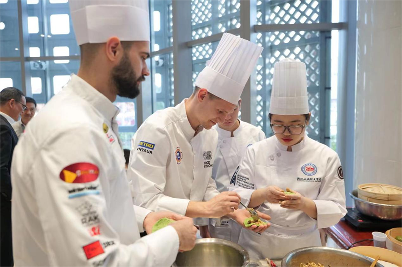 Le 11 avril, l'événement ? Merveilleux go?t chinois - Banquet du Lac de l'Ouest ? a eu lieu au Centre culturel chinois de Belgrade, capitale de la Serbie. Les plats de l'événement ont tous été préparés par des professeurs chinois et des étudiants de l’Ecole professionnelle de tourisme du Zhejiang et des étudiants serbes de l'atelier Luban. La photo montre des enseignants et des étudiants chinois et serbes confectionnant des Qingtuan, des boulettes de riz vert farcies sucrées. (Photo fournie par le Centre culturel chinois de Belgrade)