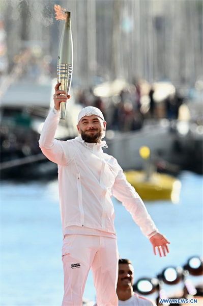 La flamme olympique arrive sur le Vieux-Port de Marseille dans une atmosphère enflammée