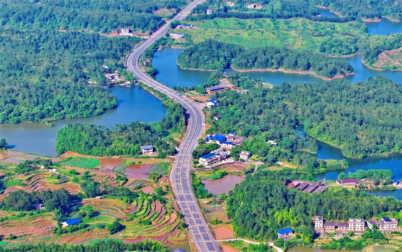 Jiangxi : à Ruijin, la route serpente à travers le paysage et les voitures traversent une nature luxuriante