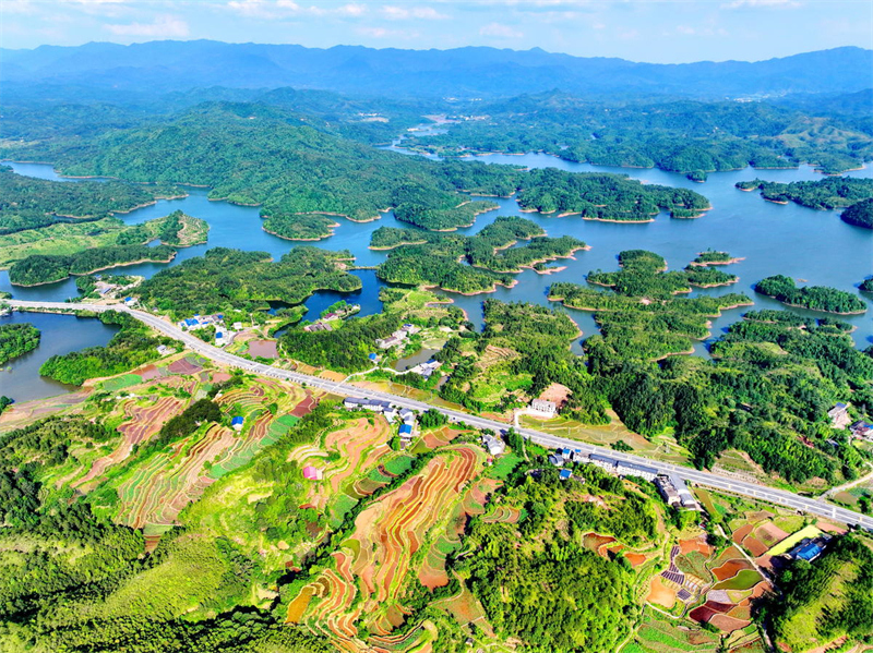 Jiangxi : à Ruijin, la route serpente à travers le paysage et les voitures traversent une nature luxuriante